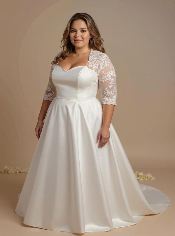 Woman wearing a ivory plus size wedding dress with lace sleeves on a beige background
