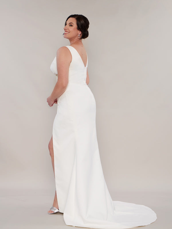 A mermaid wedding dress with a fitted bodice, a low zip back, and a sweeping train,