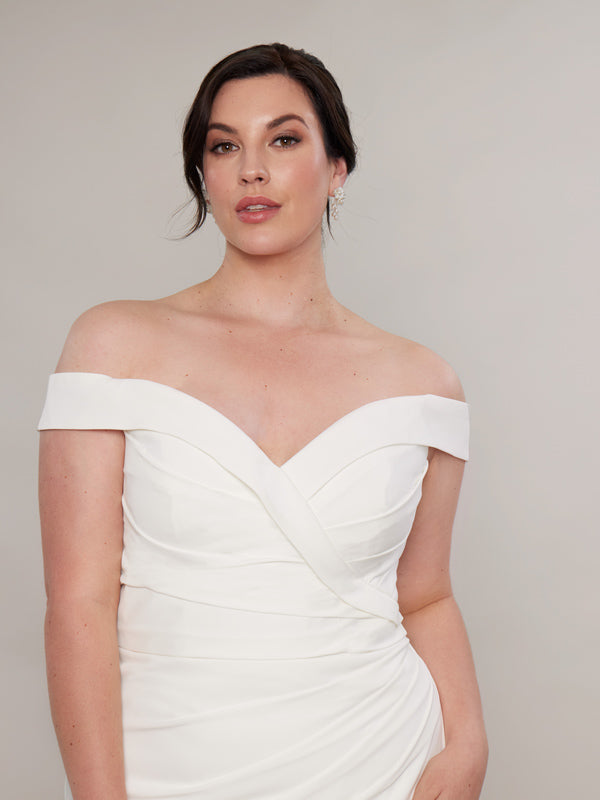 "Close-up of a bride, showcasing a chic off-the-shoulder ivory satin wedding dress featuring a sweetheart neckline and pleating on the bodice."