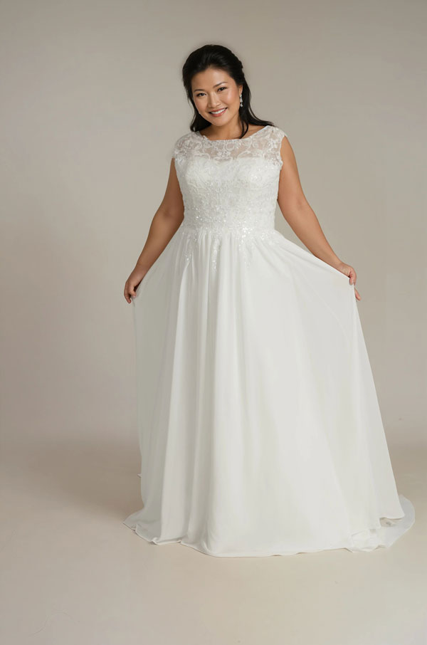 Woman wearing a white wedding dress on a plain background