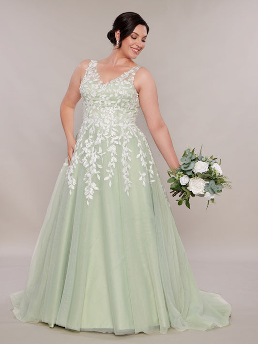 A bride wearing a green wedding dress. The dress features an A-line silhouette with leafy lace appliqué on the bodice and down the tulle skirt.