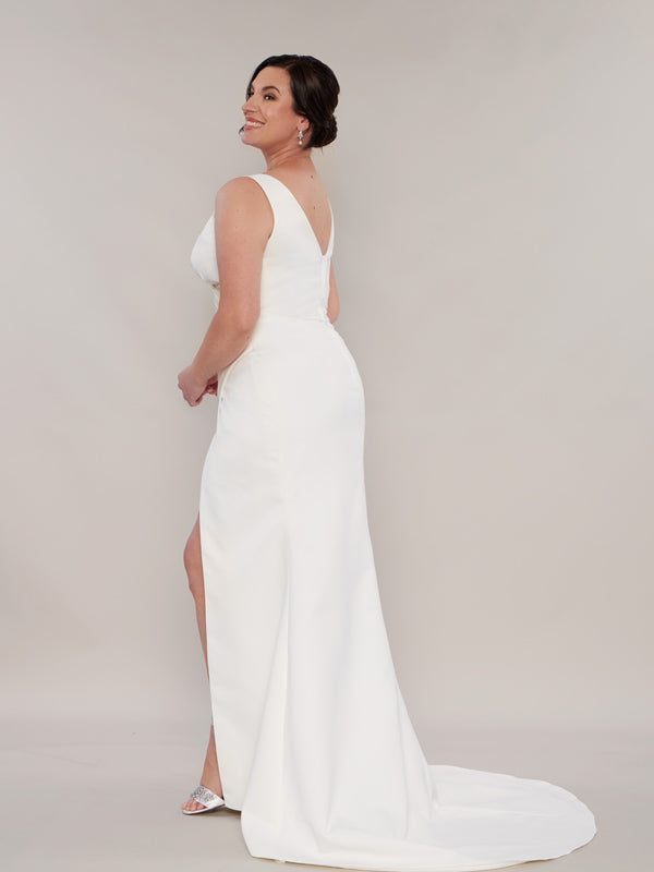 A mermaid wedding dress with a fitted bodice, a low zip back, and a sweeping train, 