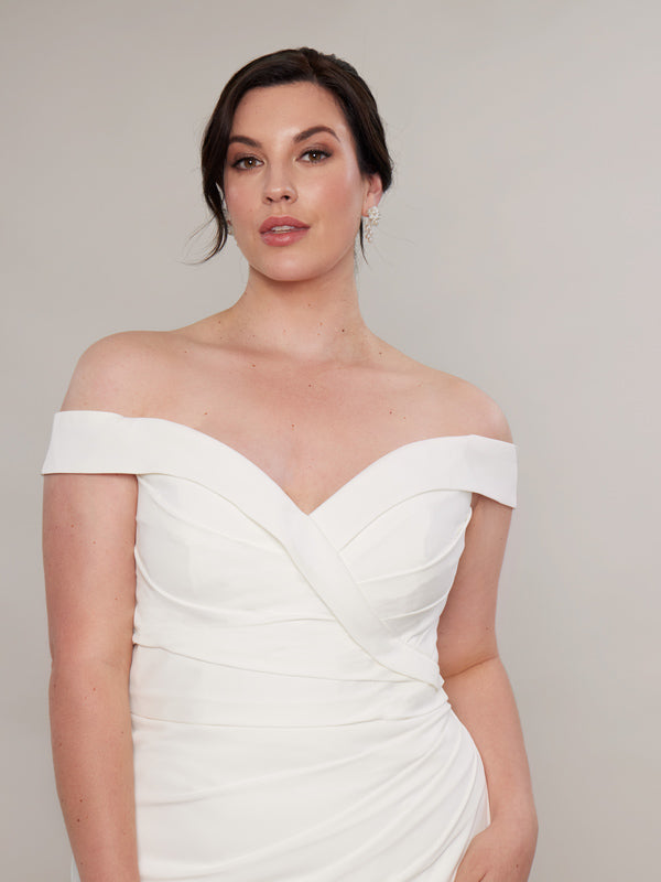  "Close-up of a bride, showcasing a chic off-the-shoulder ivory satin wedding dress featuring a sweetheart neckline and  pleating on the bodice."